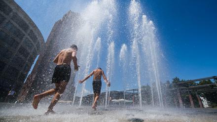 Jungen Menschen erfrischen sich am Fontänenbrunnen auf dem Walther-von-Cronberg-Platz in Frankfurt/ Main. 