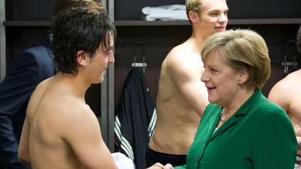 Fußballfans unter sich. Bundeskanzlerin Angela Merkel gratuliert Mesut Özil nach dem EM-Qualifikationsspiel Deutschland gegen Türkei in der Mannschaftskabine.