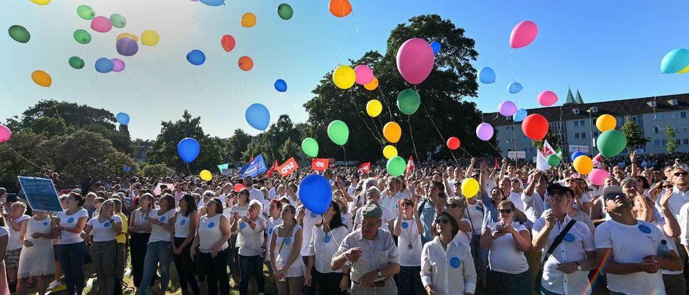 Mitarbeiter des Regierungspräsidiums lassen am Ende der Kundgebung "Zusammen sind wir stark" für Walter Lübcke 99 Luftballons in den Himmel steigen.
