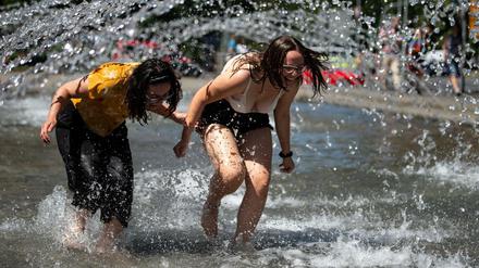 Zwei Frauen kühlen sich im Brunnen am Neuen Rathaus in Göttingen ab. 