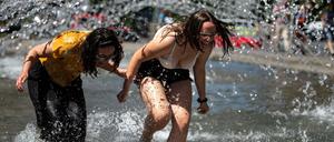 Zwei Frauen kühlen sich im Brunnen am Neuen Rathaus in Göttingen ab. 