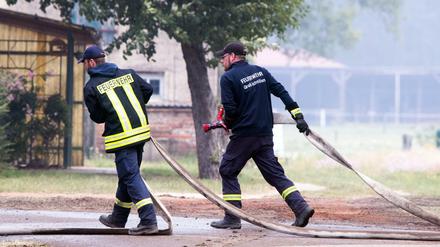 Feuerwehrleute im Einsatz im Umfeld des Waldbrandgebiets.