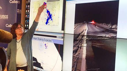 Die Seismologin Lucy Jones zeigt bei einer Pressekonferenz nach dem zweiten Beben am Freitagabend Schäden auf einem Highway.