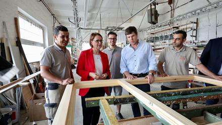 Fenster nach Sachsen: Firmenchef Dirk Frenzel (2.v.r.) mit Staatsministerin Widmann-Mauz, dem Auszubildenden Mohamed Hamza Karami (hinten) und seinen Angestellten Aziz Boutfousste (links) und Youssef Haitham.