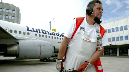 Ein Mitarbeiter betankt eine Lufthansamaschine am Flughafen Düsseldorf.