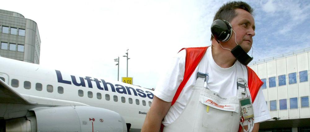 Ein Mitarbeiter betankt eine Lufthansamaschine am Flughafen Düsseldorf.