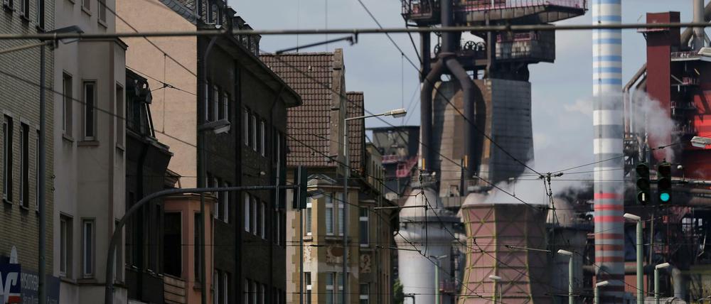 Wohnhäuser vor Fabrikgebäuden in Duisburg. 