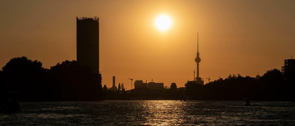 Die Sonne geht hinter dem Fernsehturm unter.