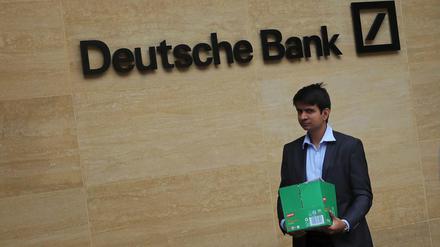 Ein Mann trägt eine Box aus der Deutschen Bank in London.