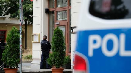 Ein Mitarbeiter der Polizeibehörde steht vor einem Restaurant in der Südvorstadt. Mit mehr als 500 Beamten ist die Bundespolizei gegen bandenmäßige Scheinehen vorgegangen.