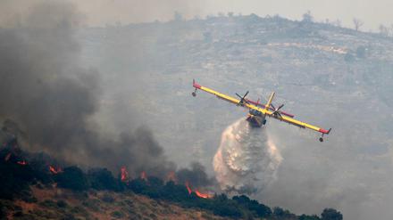 Von einem Flugzeug aus wird ein Waldbrand gelöscht.