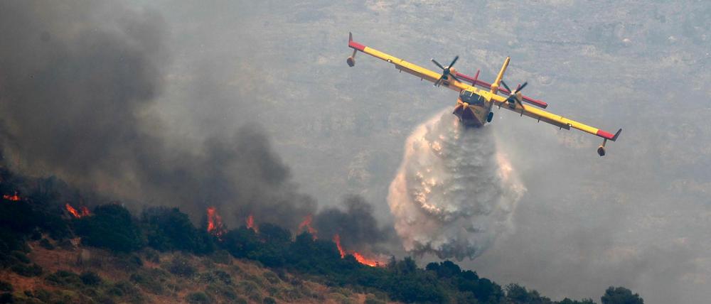 Von einem Flugzeug aus wird ein Waldbrand gelöscht.