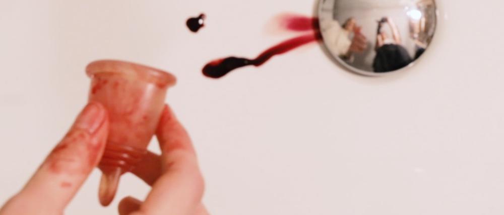 Szene aus „Let’s Talk About…“: Eine Menstruationstasse wird in den Abfluss ausgekippt.