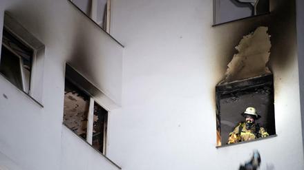 Tatort Gropiusstadt. Ein Feuerwehrmann wirft verbrannte Gegenstände aus dem Fenster der ausgebrannten Wohnung.