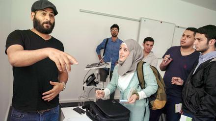 Ein Studienberater spricht im Vorbereitungskurs mit Studieninteressierten.