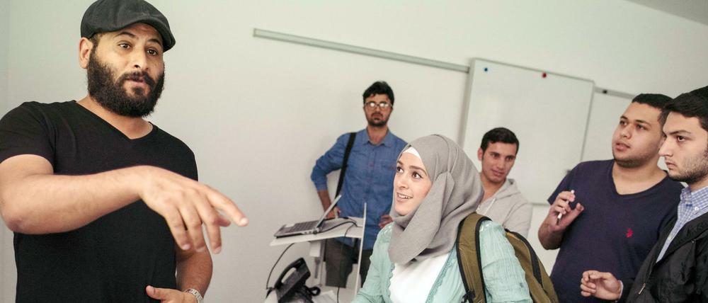Ein Studienberater spricht im Vorbereitungskurs mit Studieninteressierten.