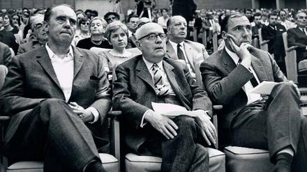 Engagement im öffentlichen Raum. Der Schriftsteller Heinrich Böll, der Philosoph Theodor W. Adorno und Suhrkamp-Verleger Siegfried Unseld (v.l.) unterstützen den Protest gegen die Notstandsgesetze. Eine Veranstaltung im Großen Sendesaal des Hessischen Rundfunks in Frankfurt am Main am 28. Mai 1968.