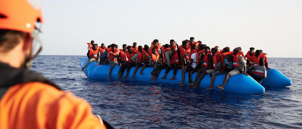 Seenotretter nähern sich einem Boot mit Geflüchteten.