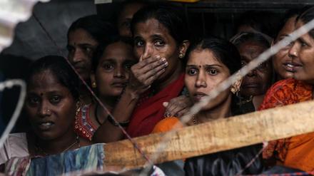 Indien: Menschen versammeln sich an dem Ort, an dem nach starken Regenfällen eine Mauer eingestürzt ist.