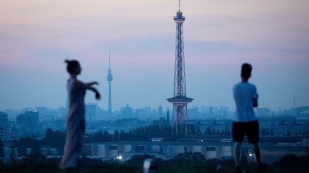 Besucher warten an einem heißen Tag auf dem Drachenberg auf den Sonnenaufgang über Berlin.