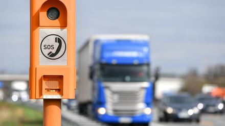 Ein Lastwagen fährt auf der A5 an einer Notrufsäule vorbei.