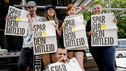 Mitglieder der Karuna Sozialgenossenschaft halten die Straßenzeitung "Karuna Kompass".