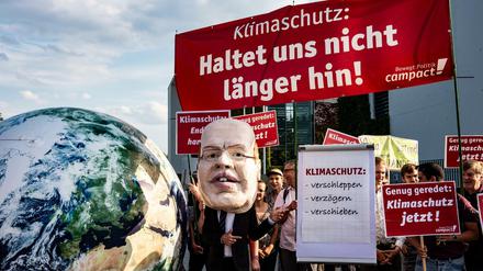 Demonstranten mit Transparenten und einer Maske von Wirtschaftsminister Altmeier stehen vor Beginn Sitzung des Klimakabinetts vor dem Bundeskanzleramt.