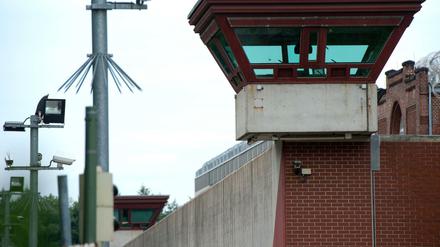 Ein Wachturm überragt die Außenmauer der JVA Tegel.