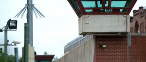 Ein Wachturm überragt die Außenmauer der JVA Tegel.