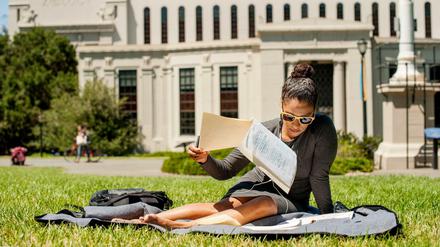 Ein Frau sitzt auf dem Universitätsgelände in Berkeley.