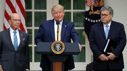 Der US-Präsident Donald Trump im Rosengarten des Weißen Hauses mit Handelsminister Wilbur Ross (l) und Justizminister William Barr.