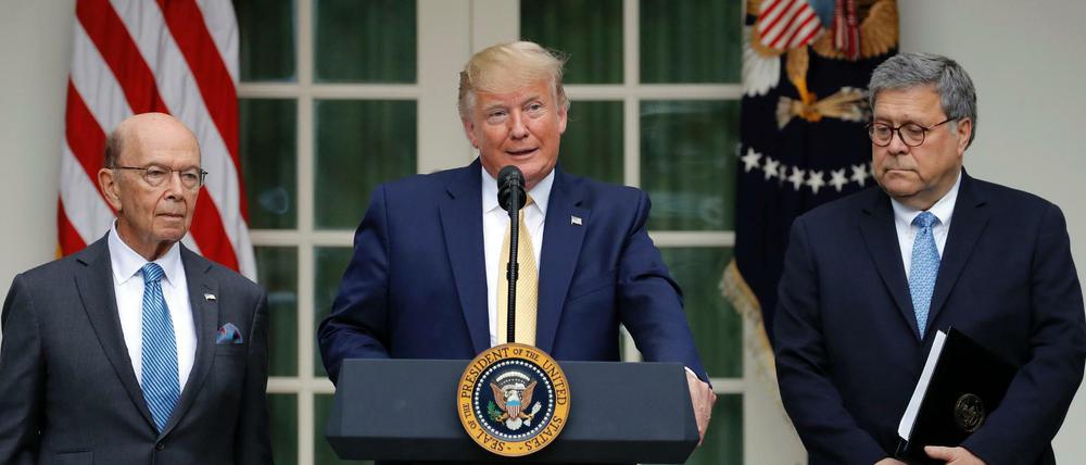 Der US-Präsident Donald Trump im Rosengarten des Weißen Hauses mit Handelsminister Wilbur Ross (l) und Justizminister William Barr.