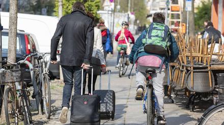 Fahrradfahrer und Fußgänger auf einem engen Bürgersteig in Berlin.