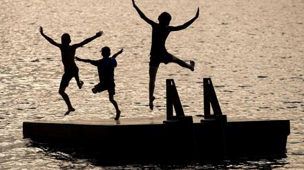 Kinder springen von einer Schwimminsel (Symbolfoto).