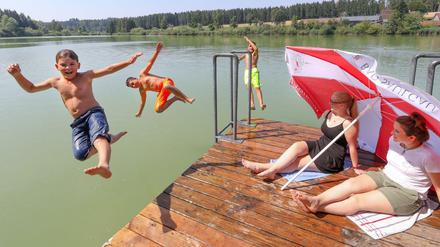 Baden-Württemberg, Bad Saulgau: Drei Jungen suchen Abkühlung im Wasser. 