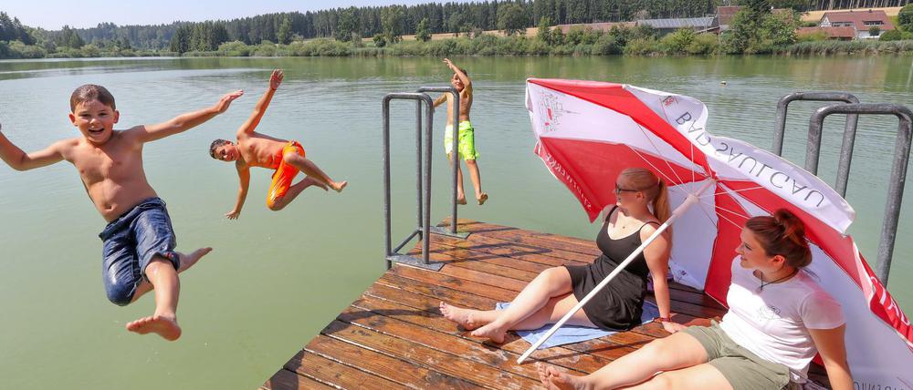 Baden-Württemberg, Bad Saulgau: Drei Jungen suchen Abkühlung im Wasser. 