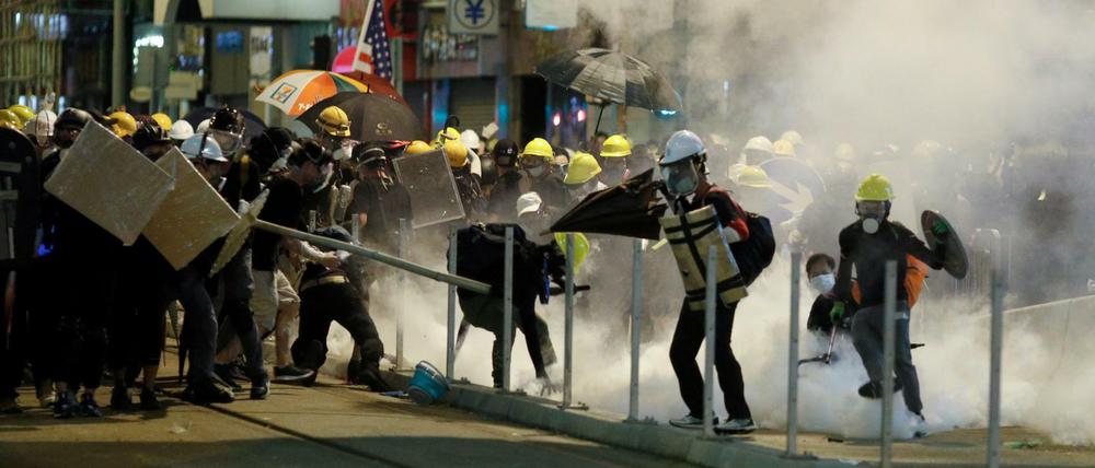Die Demonstranten reagieren auf Tränengas während Zusammenstoßen mit Polizisten.
