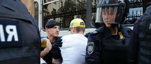 Polizeibeamte verhaften einen Mann vor einer Kundgebung in Moskau.