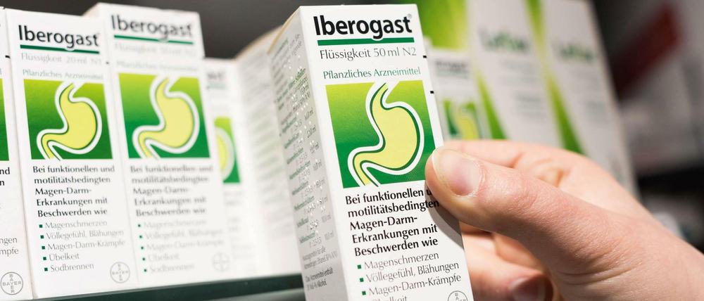 Eine Apothekerin hält das rezeptfreie Magenmittel IBEROGAST in der Hand. 