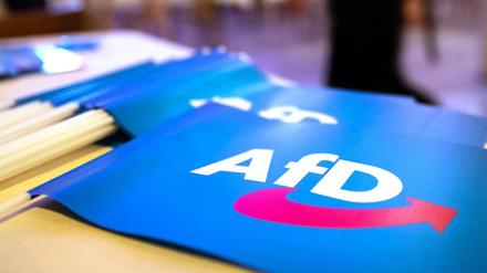 Fähnchen mit dem Logo der AfD liegen bei einem Landesparteitag der AfD auf einem Tisch (Symbolbild). 