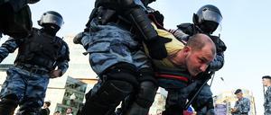 Polizisten nehmen einen Demonstranten fest. 