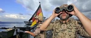 Deutsche Marine-Soldaten halten an Bord der Fregatte „Karlsruhe“ an einem Maschinengewehr Wache. 
