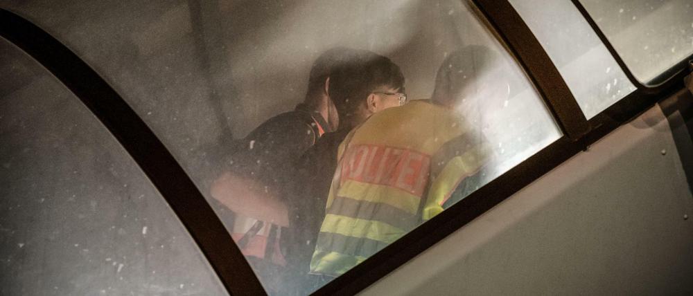 Polizeibeamte begleiten einen Afghanen auf dem Flughafen Leipzig-Halle in ein Charterflugzeug. 45 abgelehnte Asylbewerber wurden mit dem Sonderflug in Afghanistans Hauptstadt Kabul abgeschoben.