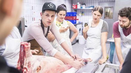 Fleischerei Kumpel &amp; Keule in Kreuzberger Markthalle Neun: Metzger Jörg Förstera (mit Base-Cap) demonstriert sein Handwerk
