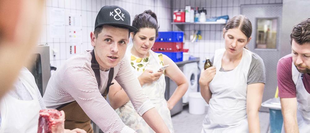 Fleischerei Kumpel & Keule in Kreuzberger Markthalle Neun: Metzger Jörg Förstera (mit Base-Cap) demonstriert sein Handwerk