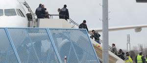 Abgelehnte Asylbewerber steigen in ein Flugzeug.