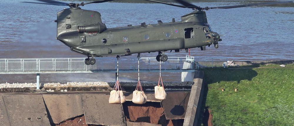 Ein RAF CH-47 Chinook Hubschrauber trägt Sandsäcke, um den Staudamm am Toddbrook nahe Whaley Bridge zu verstärken.