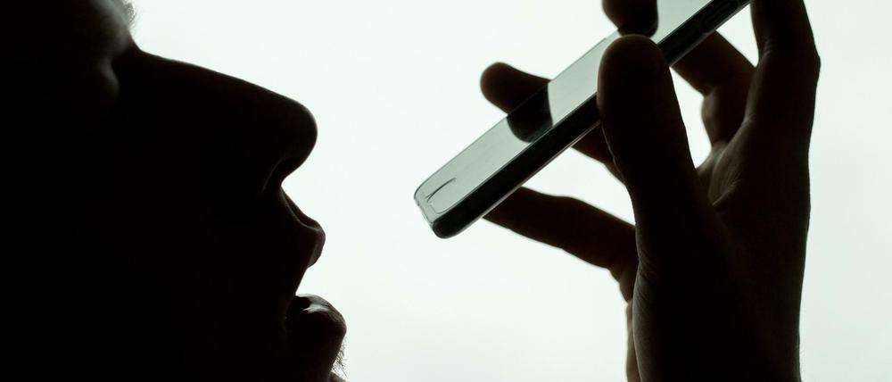 Ein Mann spricht in sein iPhone (Symbolbild).