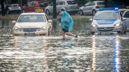 Ein Mann geht über die überflutete Tiergartenstraße in Berlin Mitte. Mehrere Autos blieben im teilweise Knietiefen Wasser liegen. 