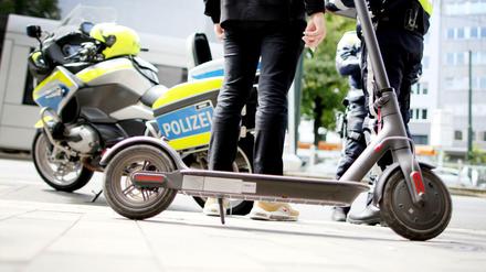 Polizisten kontrollieren in der Innenstadt von Düsseldorf einen E-Scooter-Fahrer